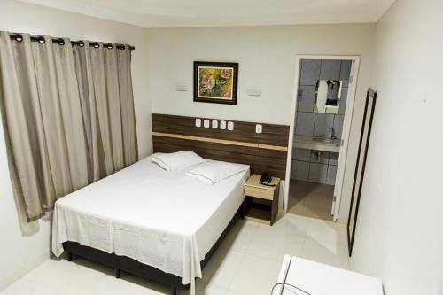 Un pat sau paturi într-o cameră la Pôr do Sol Hotel