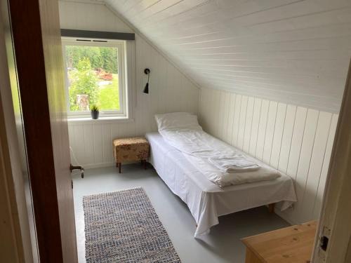 a small bedroom with a bed and a window at Feriehus i landlige område med nydelig utsikt in Leirvik