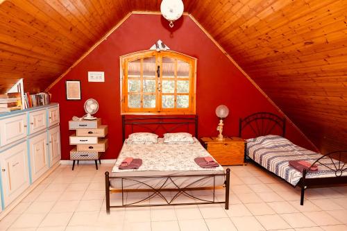 een slaapkamer met 2 bedden op een zolder bij Cheerful artist villa in the genuine part of Evia Greece in Kastríon