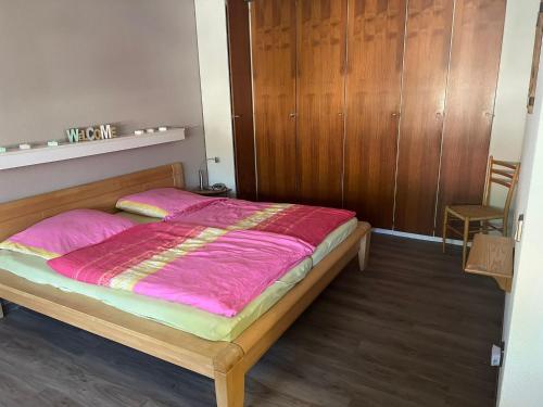 a bedroom with a bed with a pink comforter at Haus enere Au in Todtmoos