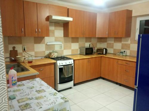 a kitchen with wooden cabinets and a stove top oven at Сонячний Котедж in Slavske