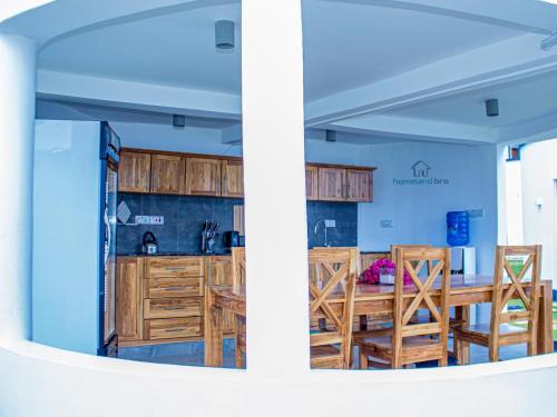 a kitchen and a dining room with wooden cabinets at homeland bro in Dar es Salaam