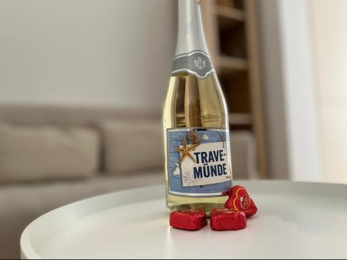 a bottle of wine and some red roses on a table at Strand Studio mit Meerblick & Balkon in Lübeck