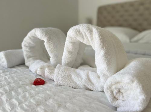 a bed with white towels and a red rose on it at Strand Studio mit Meerblick & Balkon in Lübeck