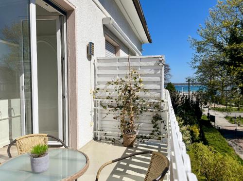 a patio with a table and chairs and a fence at Strand Studio mit Meerblick & Balkon in Lübeck