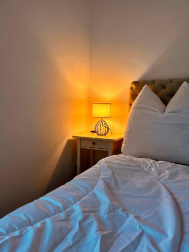 a bedroom with a bed and a table with a lamp at Strand Studio mit Meerblick & Balkon in Lübeck