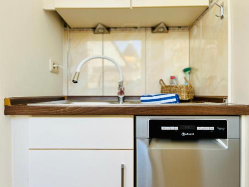 uma cozinha com um lavatório e uma máquina de lavar louça em Strand Studio mit Meerblick & Balkon em Lübeck