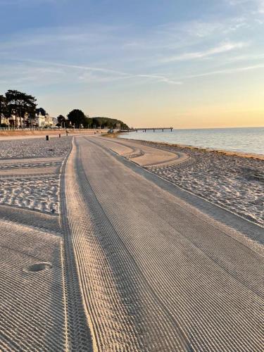 an empty beach with tracks in the sand and the ocean at Strand Studio mit Meerblick & Balkon in Lübeck