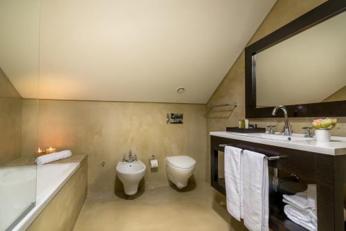 a bathroom with a toilet and a sink and a mirror at Universal Boutique Hotel in Figueira da Foz