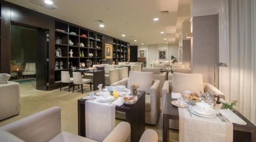 a dining room with white tables and chairs and a restaurant at Universal Boutique Hotel in Figueira da Foz
