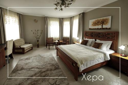 a large bedroom with a large bed and a chair at Boutique & Spa Hotel Heaven in Velingrad