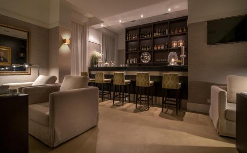a bar with chairs and a counter in a room at Universal Boutique Hotel in Figueira da Foz