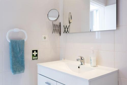 a white bathroom with a sink and a mirror at Casa Primavera - renovated duplex in city centre in Funchal
