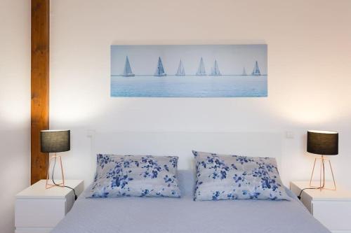 a bedroom with a bed with two lamps and sailboats at Casa Primavera - renovated duplex in city centre in Funchal