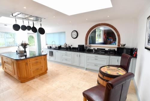 a kitchen with white cabinets and a counter top at Luxury property - Swimming Pool, Outdoor Kitchen, Games Room & Hot Tub in Usk