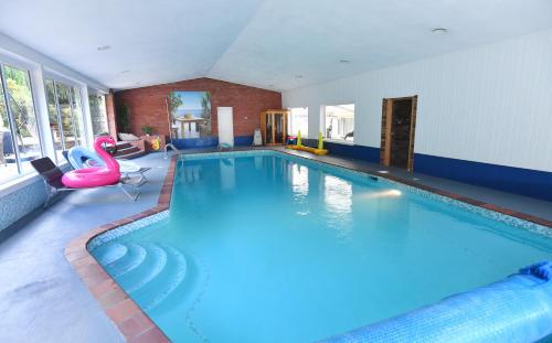 a large swimming pool in a hotel room at Luxury property - Swimming Pool, Outdoor Kitchen, Games Room & Hot Tub in Usk