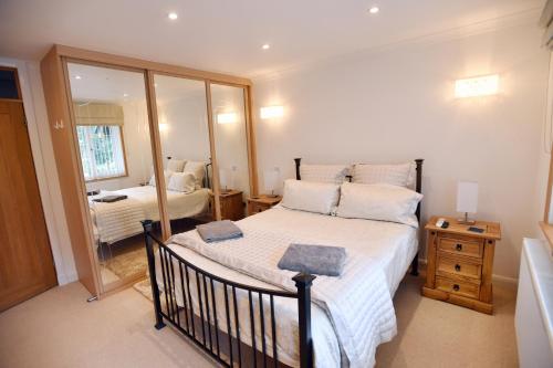 a bedroom with a large bed and a mirror at Luxury property - Swimming Pool, Games Room & Hot Tub in Usk