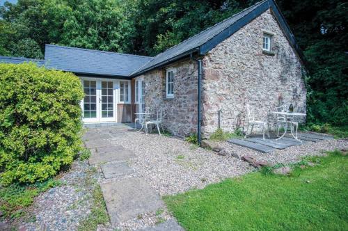 a stone house with two chairs in front of it at Brynach - 1 Bedroom - St Ishmaels in Saint Ishmaels