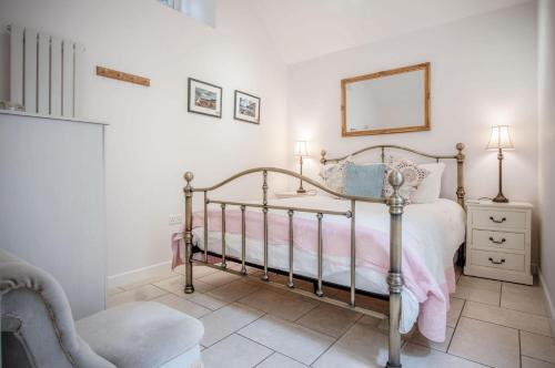 a bedroom with a bed and a chair and a mirror at Caradog - 1 Bedroom - St Ishmaels in Saint Ishmaels