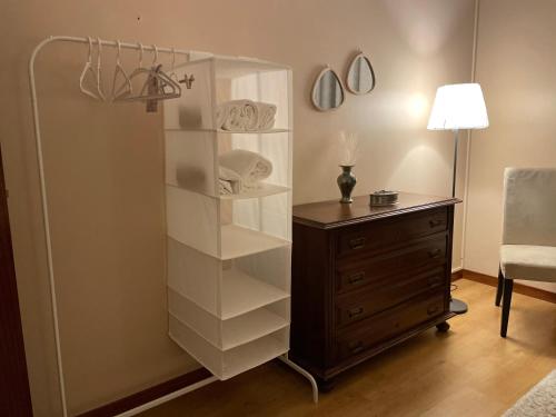 um quarto com uma prateleira de livros brancos ao lado de uma cómoda em S. Mamede House - Penafiel em Recezinhos