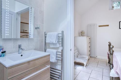 a white bathroom with a sink and a mirror at Caradog - 1 Bedroom - St Ishmaels in Saint Ishmaels