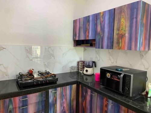 a kitchen with a stove and a microwave on a counter at Luxury 3BHK Aprtmnt City View Balcony HSpeed Wifi Free Parking in Kolkata