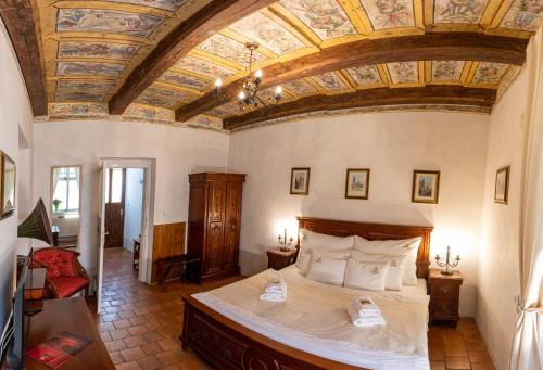 1 dormitorio con 1 cama grande y techo artesonado en Loreta Hotel, en Praga