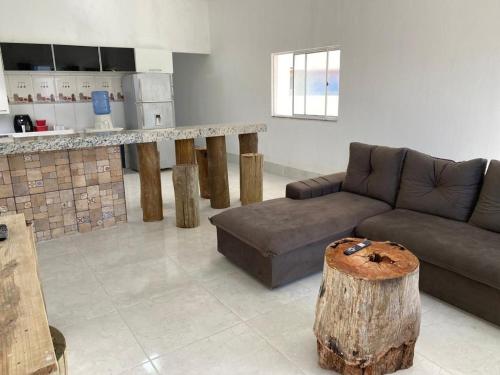 uma sala de estar com um sofá e um tronco no meio em Casa de Praia do Marcinho em Prado