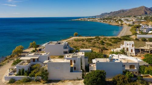 an aerial view of a white house and the ocean at Akrotiri Apartments in Makry Gialos