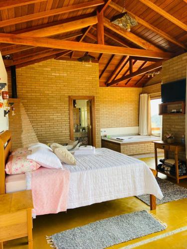 a bedroom with a large bed in a room at Chalés Terras Altas in Gonçalves