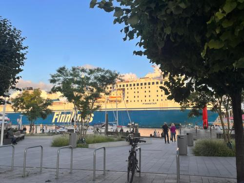 a bike parked on a sidewalk in front of a cruise ship at Strand Studio mit Meerblick & Balkon in Lübeck