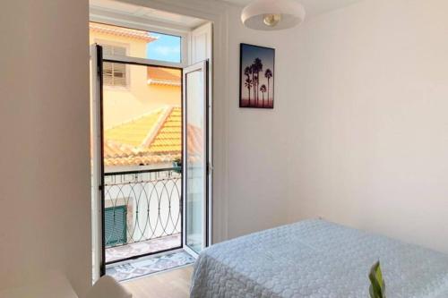 1 dormitorio con 1 cama y balcón en Apartment Primavera: City centre, modern w/balcony en Funchal