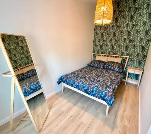 een kleine slaapkamer met een bed en een spiegel bij Apartament Miętowy - Centrum Poznańska in Bydgoszcz