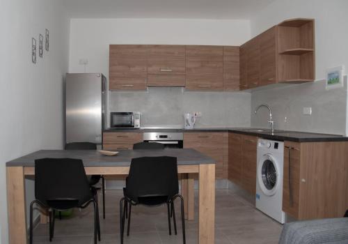 a kitchen with a table and chairs and a refrigerator at Cerviola Etrin Court in Marsaskala