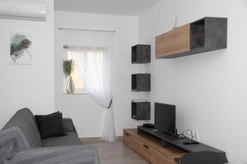 a living room with a couch and a tv at Cerviola Etrin Court in Marsaskala