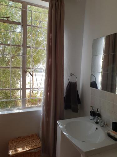 a bathroom with a sink and a window at Loveable Karoo Cottages in Fraserburg
