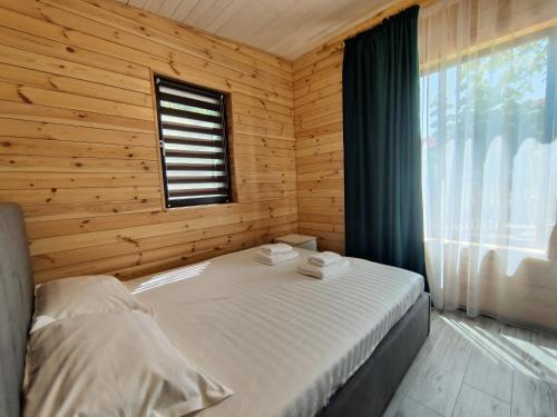 a bedroom with a bed in a wooden cabin at Kub Baile Govora in Băile Govora