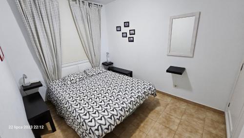 a bedroom with a black and white bed and a mirror at Puerto Rico Top Teide and Amadores View in Puerto Rico de Gran Canaria