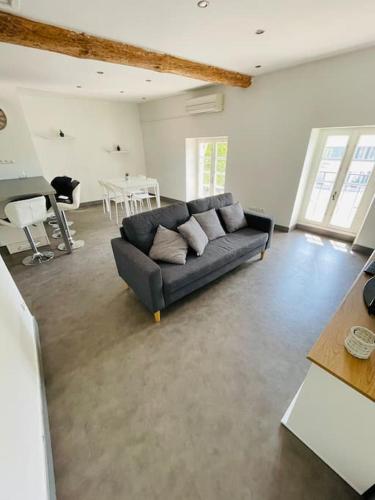 un salon avec un canapé noir et une table dans l'établissement Chez Léo III, à Bollène