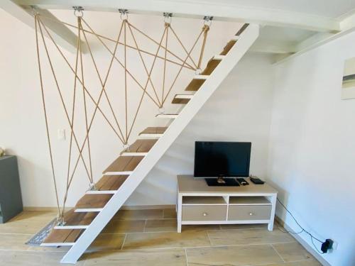 Cette chambre dispose d'un escalier, d'un bureau et d'une télévision. dans l'établissement Suzon Petit loft Terrasse et Clim Coté Mairie, à Sète