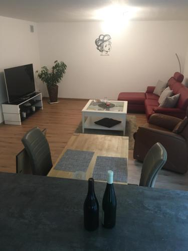 a living room with a table with two bottles on it at Peter's Ferienwohnung Nahe Rust, Kehl, Straßburg, Offenburg in Neuried