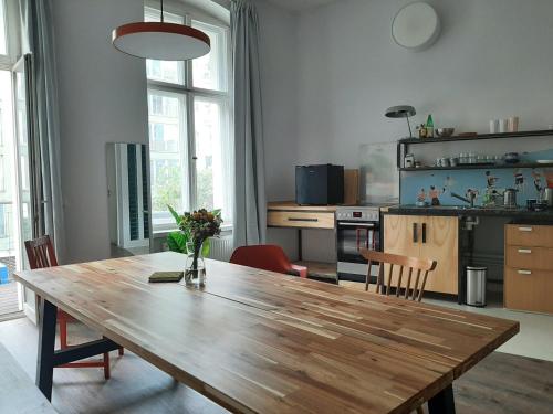une cuisine avec une table en bois et une salle à manger dans l'établissement Artist Studio - Berlin - Prenzlauer Berg, à Berlin