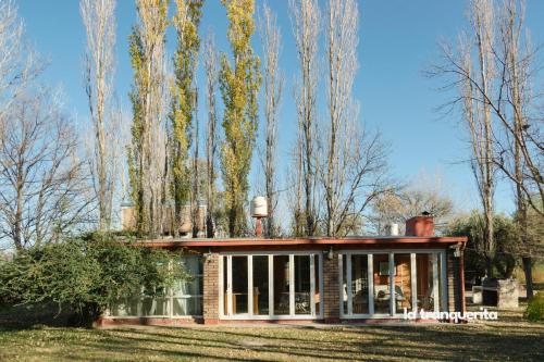 a house in a field with trees in the background at Finca La Tranquerita in San Rafael
