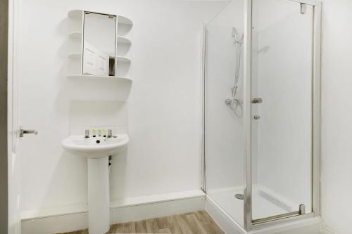 a white bathroom with a sink and a shower at Spacious 5-Bed Flat in Stockton, Sleeps 9 in Stockton-on-Tees