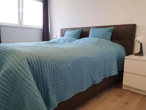 a bed with a blue comforter in a bedroom at Ferienwohnung direkt am Kurpark Laga mit Gradierwerk Solestadt in Bad Dürrenberg