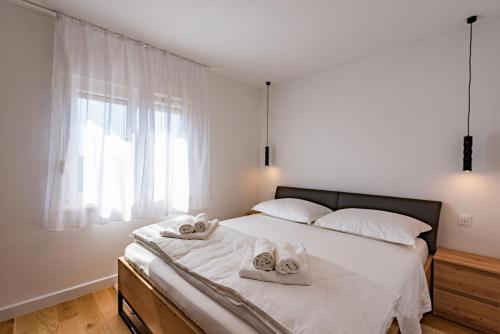 a bedroom with a bed with two towels on it at Penthouse with view in city center in Split