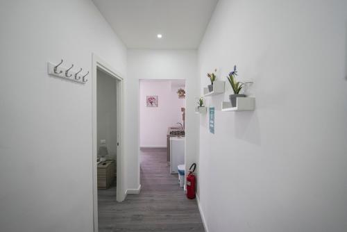 um quarto com paredes brancas e um corredor com uma mesa em Capodichino Apartment 127 - 20 em Nápoles