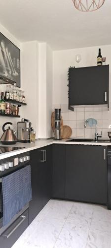 eine Küche mit schwarzen Schränken und einer Arbeitsplatte in der Unterkunft Kleiner Urwald in Remscheid