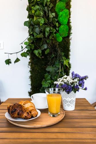 a table with a plate of bread and a glass of orange juice at Penthouse with view in city center in Split