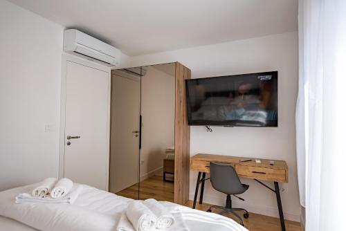 a bedroom with a bed and a desk with a television at Penthouse with view in city center in Split